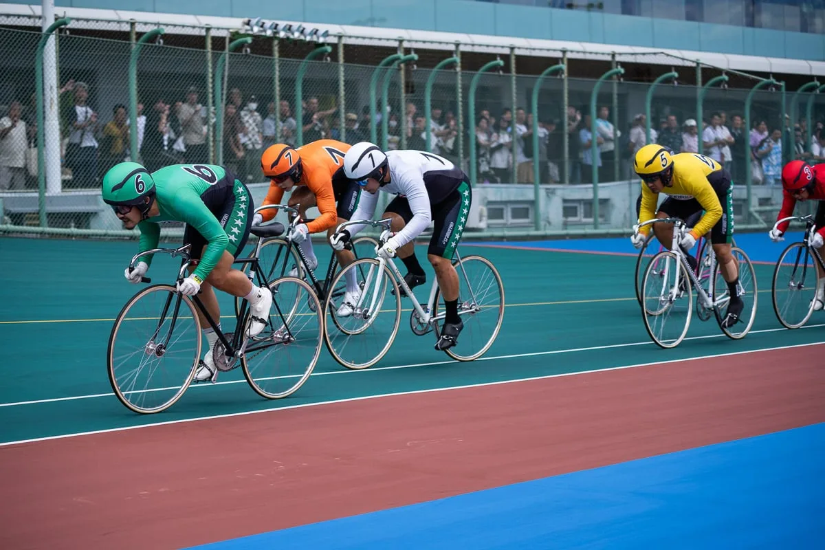 バンクで先行争いを繰り広げる競輪選手たち